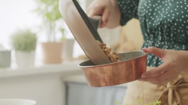 自宅のキッチンテーブルのプレートに熱いウォークナットを提供する匿名の女性料理のサイドビュー — ストック動画
