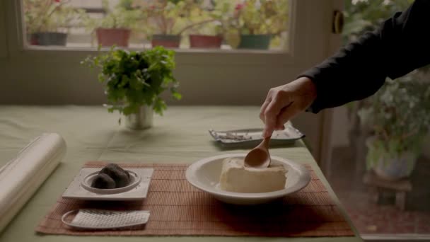 作物匿名料理粉砕柔らかいチーズとともに木製のへら近くのトリュフプレート上のテーブルの上に家 — ストック動画