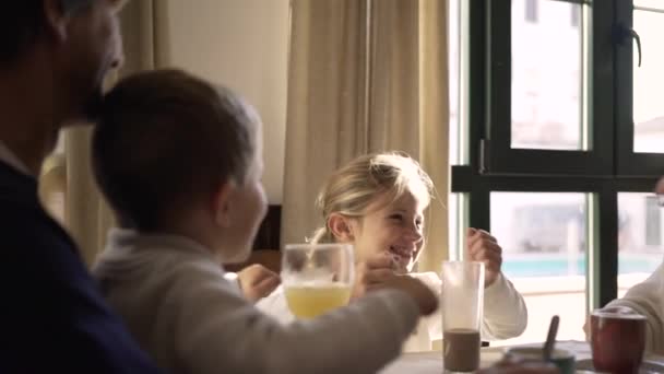 快乐的小孩一边吃饭一边玩乐 一边和快乐的父母在家里吃早餐时喝酒 — 图库视频影像