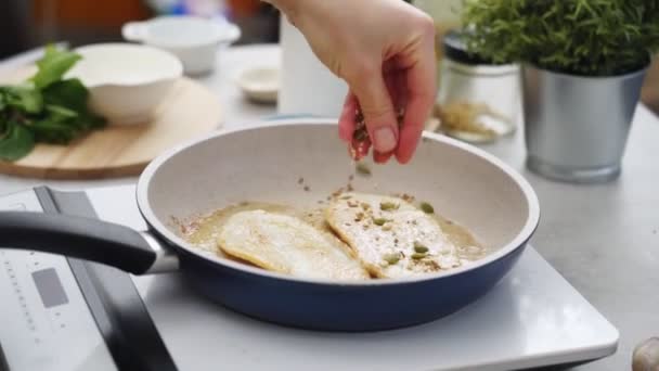 キッチンで食欲をそそる料理を準備しながら 電気ストーブに置かれた鍋にカボチャの種を注ぐ匿名調理の高角度 — ストック動画