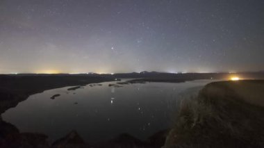 Barrancas de Burujon 'daki dağların ve nehrin siluetinin üzerinden geçen yıldızların zaman akışı.