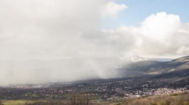 Yüksek bir dağ kasabasında yağmur yağışı yapan bulutların zaman akışı
