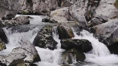 Kayalık taşların arasında akan köpüklü su akıntısı