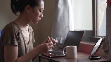 Evinin oturma odasında çalışan bir kadın.