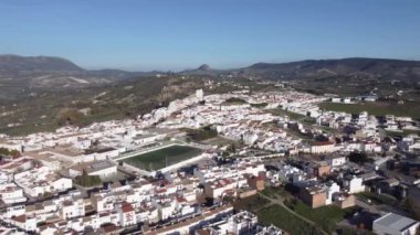 Güneşli bir günde İspanya 'da Cadiz sokaklarındaki tepenin etrafındaki beyaz evlerin insansız hava aracı görüntüsü.