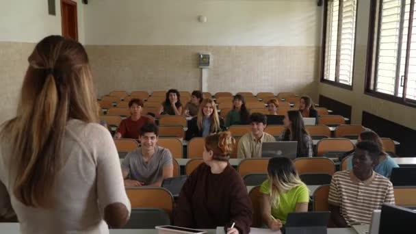 匿名の先生の後ろから講演会場に座っている生徒のグループまで — ストック動画