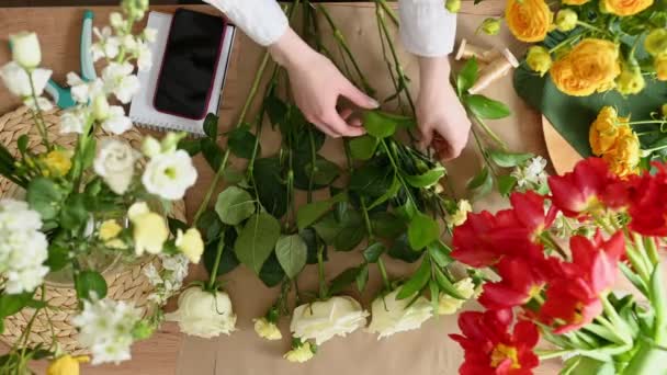 위에서 꽃집에서 앞치마 테이블에 상점에서 신선한 꽃다발을 만드는 — 비디오