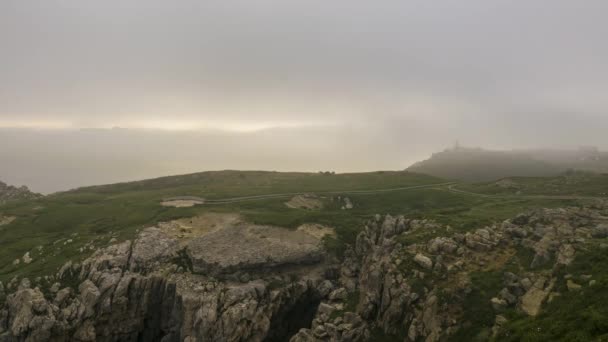 Статический Снимок Облаков Тумана Плавающих Над Скалистой Скалой Покрытой Зеленой — стоковое видео