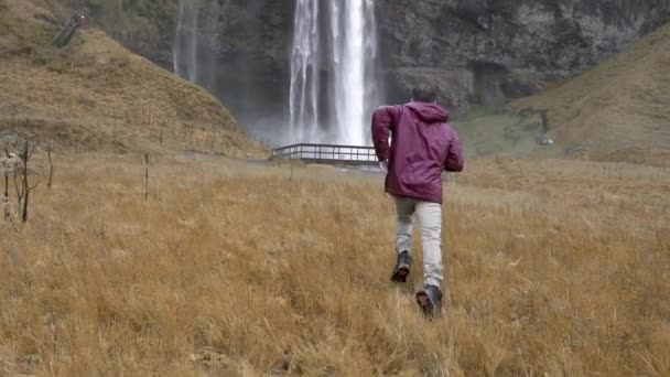 Zadní Pohled Nepoznatelného Muže Cestovatele Mokrých Šatech Běžící Podél Pole — Stock video