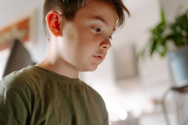 Güneşli bir günde evde dinlenirken küçük sevimli bir çocuğun düşük ekin açısı.