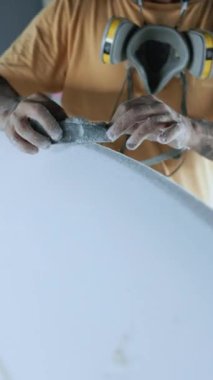 Boyunda dövmeli kolları ve solunum cihazıyla tanınmayan, profesyonel ekipmanlarla sörf tahtasının sınırını oluşturan el kamerası görüntüsü.