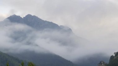 Picos de Europa engebeli kayalık dağ sırtı üzerinde yeşil otlarla kaplı kasvetli bulutların düşük açılı zaman akışı