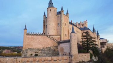 İspanya 'nın Avila kentindeki bulutlu günbatımına karşı Segovia Alcazar' ın hava görüntüsünü yükselt