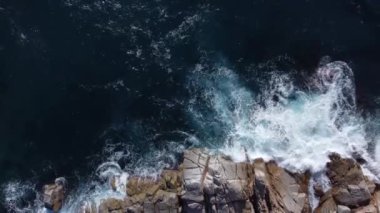 Güneşli Girona gününde kayalık kayalıklara çarpan güçlü mavi denizin köpüklü dalgalarının nefes kesici görüntüsü.