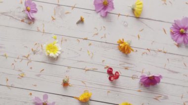 Dönerken beyaz ahşap bir masada bahar çiçeklerinin üst görüntüsü