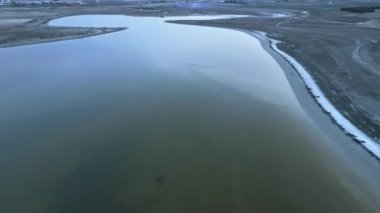 İspanya 'daki durgun göl su yüzeyinde uçan beyaz kuş sürüsünün drone görüntüsü