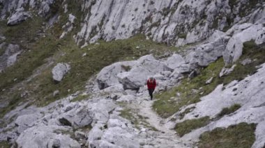 Sırt çantalı bir turist yüksek kayalıklarda yürüyor
