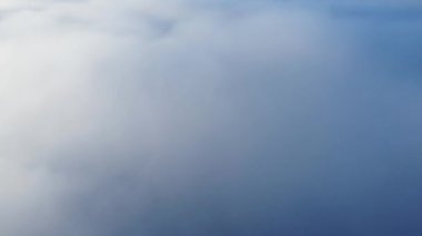 Yavaş çekim drone görüntüsü beyaz kabarık bulutlar üzerinde yüksek açı gündüz gökyüzünü kaplıyor