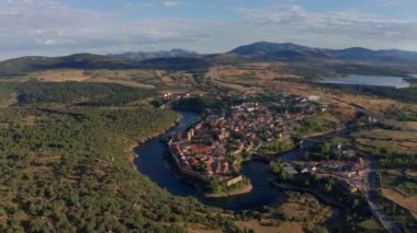 Buitrago del Lozoya 'nın dolambaçlı nehir ve otlaklarla çevrili eski bir kasabasının insansız hava aracı görüntüsü