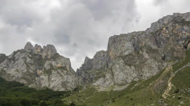 Picos de Europa engebeli kayalık dağ sırtı üzerinde yeşil otlarla kaplı kasvetli bulutların düşük açılı zaman akışı