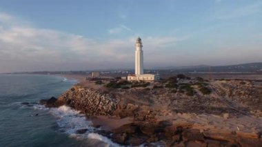 İspanya 'nın Cadiz ilindeki kayalık deniz kıyısındaki eski Trafalgar deniz feneri kulesinin insansız hava aracı görüntüsü