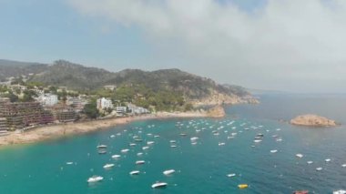 Sahili ve tekneleri olan güzel kayalık bir sahil.