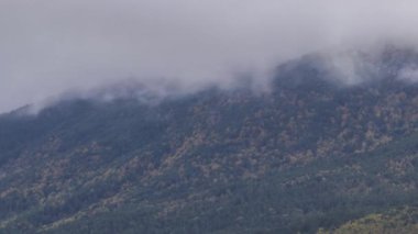 Picos de Europa engebeli kayalık dağ sırtı üzerinde yeşil otlarla kaplı kasvetli bulutların düşük açılı zaman akışı