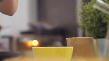 İsimsiz profesyonel aşçı mutfakta bir kepçeyle krep hamurunu tavaya koyuyor.