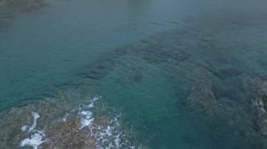 Doğal Park Cabo de Gata yakınlarındaki dalgalı okyanus suyunun dalgalanan turkuaz kayalık kayalıklarının yukarıdan insansız hava aracı görüntüsü.