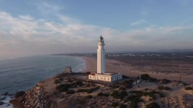 İspanya 'nın Cadiz ilindeki kayalık deniz kıyısındaki eski Trafalgar deniz feneri kulesinin insansız hava aracı görüntüsü