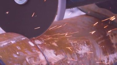 Metal işçiliğinin kenarlarını öğüten eldivenli ekin metal işçisi.