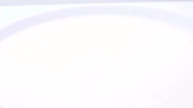 Yeşil yapraklı taze olgun çileklerin yavaşça kaseye düşüşü.