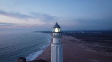 İspanya 'nın Cadiz ilindeki kayalık deniz kıyısındaki eski Trafalgar deniz feneri kulesinin insansız hava aracı görüntüsü