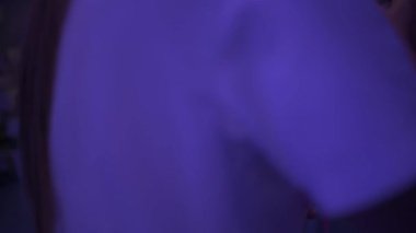 Yukarıdaki hemşire, hastanede fototerapi için ultraviyole altında bebek kuvözünde yatan hasta bebeği kucağında tutuyor.