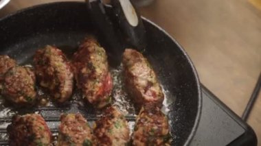 Yukarıdan maşa kullanan isimsiz bir kişiden evde öğle yemeği hazırlarken kızgın yağlı tavada lezzetli Salisbury bifteği yapmaya kadar.