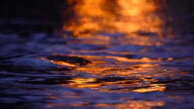 Doğal doku ve arkaplan, gece parlak ışığı yansıtan koyu dalgalı su.