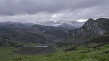 Picos de Europa dağ sırtının İspanya 'da yüzen bulutların altında bulunan küçük göl yakınlarındaki zaman kayması