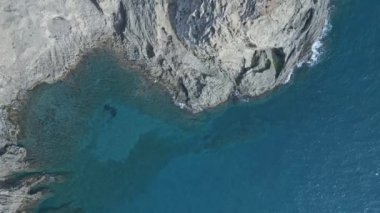 Doğal Park Cabo de Gata yakınlarındaki dalgalı okyanus suyunun dalgalanan turkuaz kayalık kayalıklarının yukarıdan insansız hava aracı görüntüsü.