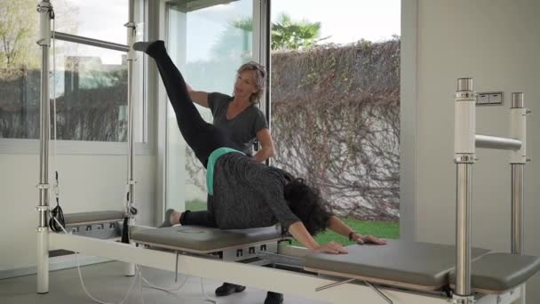 Kvinna Aktiva Kläder Praktiserar Yoga Nedåtvänd Hundhållning Pilates Reformator Med — Stockvideo