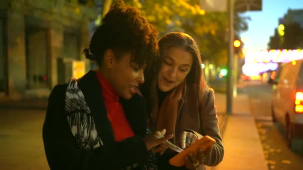 Δύο Φίλοι Που Χρησιμοποιούν Ένα Smartphone Στη Νυχτερινή Πόλη — Αρχείο Βίντεο