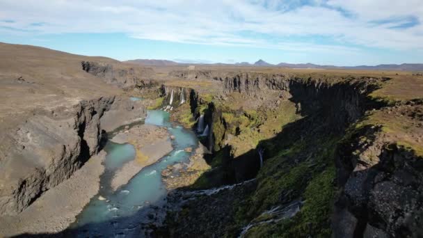 아이슬란드의 지형에서 청록색 강으로 흐르는 폭포의 항공기 전망에서 — 비디오
