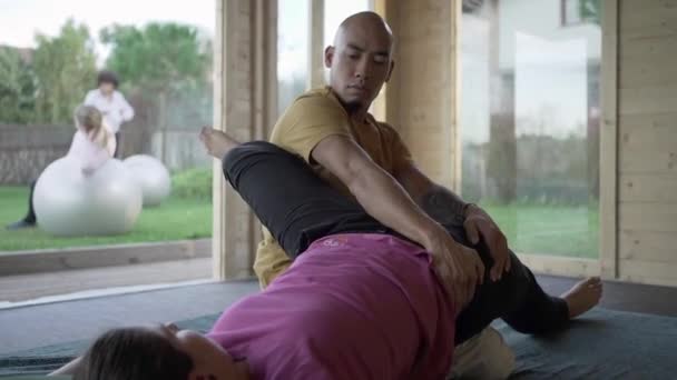 Van Boven Van Mannelijke Therapeut Stretching Benen Van Serene Vrouw — Stockvideo