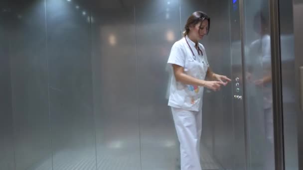 Жінка Повним Тілом Білій Медичній Формі Натискає Кнопку Всередині Ліфта — стокове відео