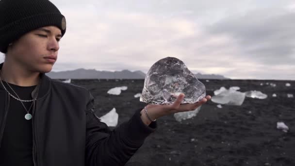Мужчина Теплой Куртке Шляпе Демонстрирует Холодный Кусок Льда Руках Исландии — стоковое видео
