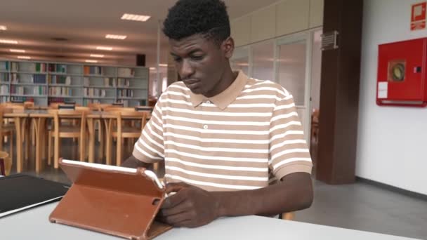 Joven Afroamericano Sentado Mesa Biblioteca Trabajando Con Tablet Computer — Vídeo de stock