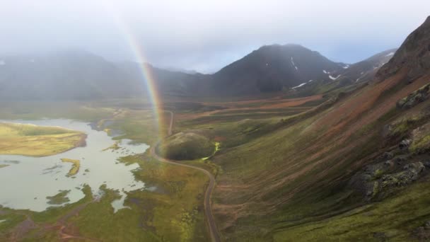 从那令人惊叹的无人俯瞰的绿山和平静的湖面俯瞰着冰岛多云的天空 彩虹映衬着火山地形 — 图库视频影像