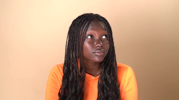 Ung Afroamerikansk Kvinna Orange Outfit Står Studio Beige Bakgrund Visar — Stockvideo