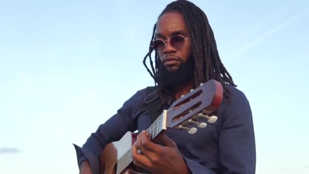 Brodaty Etniczny Facet Okularach Wykonujący Muzykę Gitarze Akustycznej Kamiennej Granicy — Wideo stockowe
