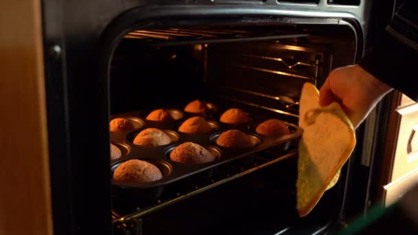 キッチンでオーブンおいしい自家製マフィンから取る作物認識できないお菓子 — ストック動画
