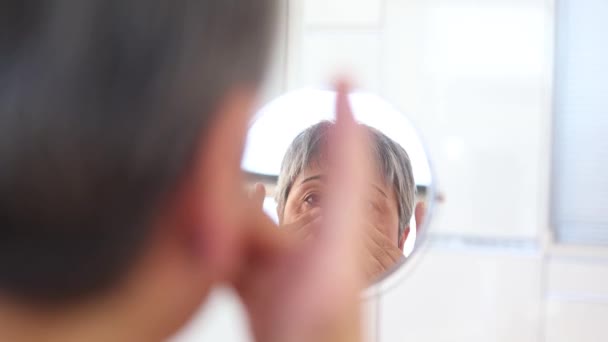 Mujer Adulta Albornoz Blanco Untando Crema Hidratante Cara Mirando Espejo — Vídeos de Stock